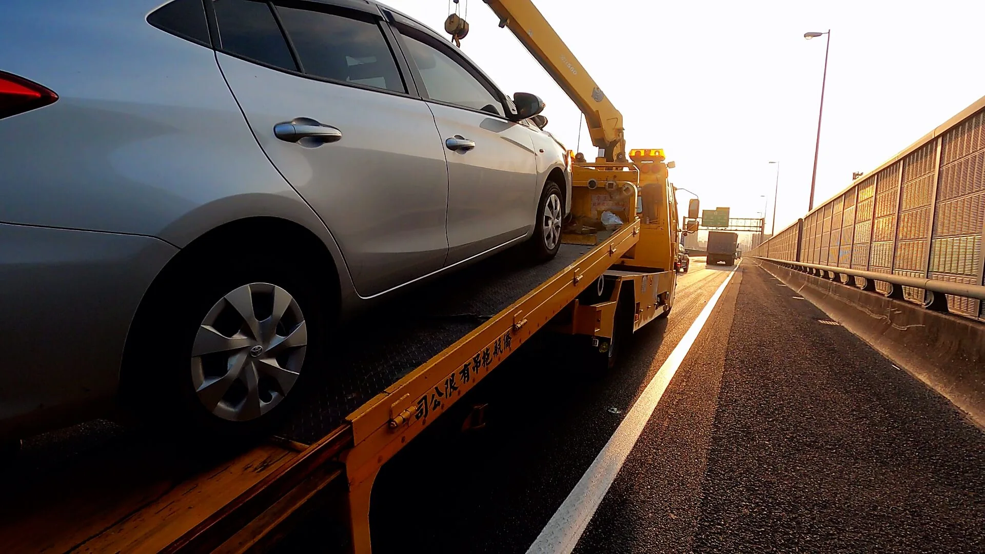 Photo of the founder working next to a tow truck in his early days.